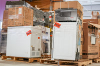 Stacked appliances on pallets with cardboard boxes in a warehouse setting